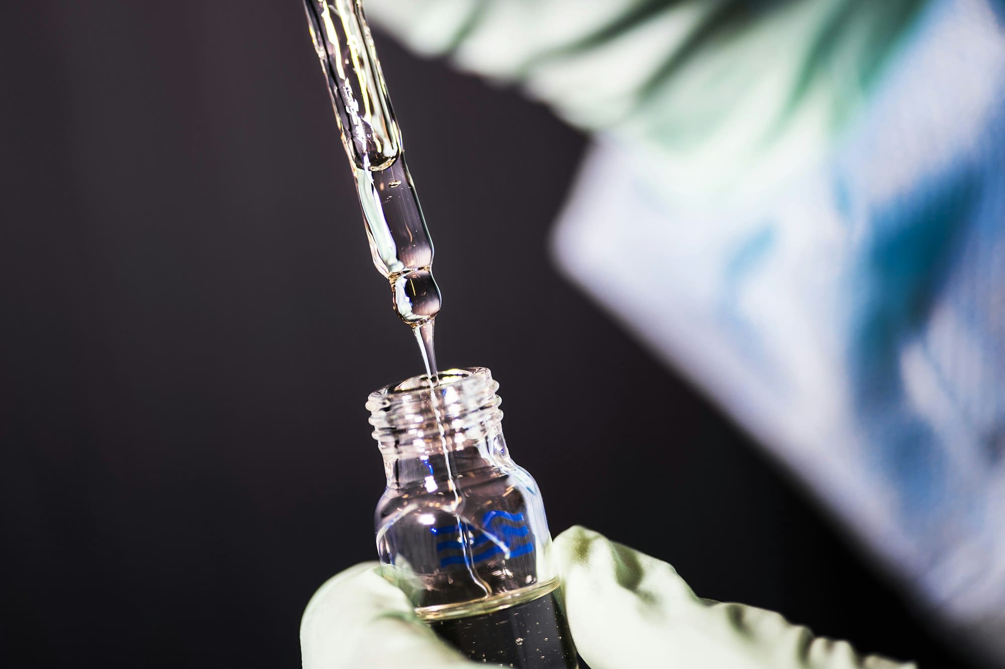Pipet doseert vloeistof in een glazen vial
