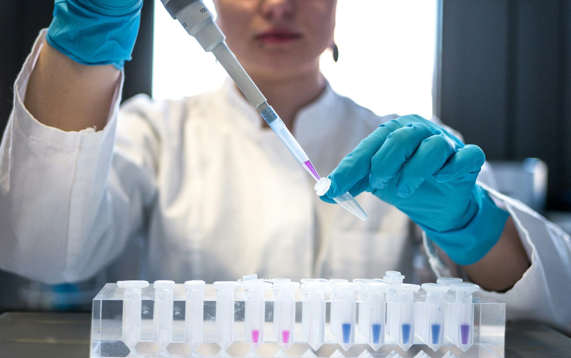 Analist pipetteert monsters in een rij vials in het laboratorium